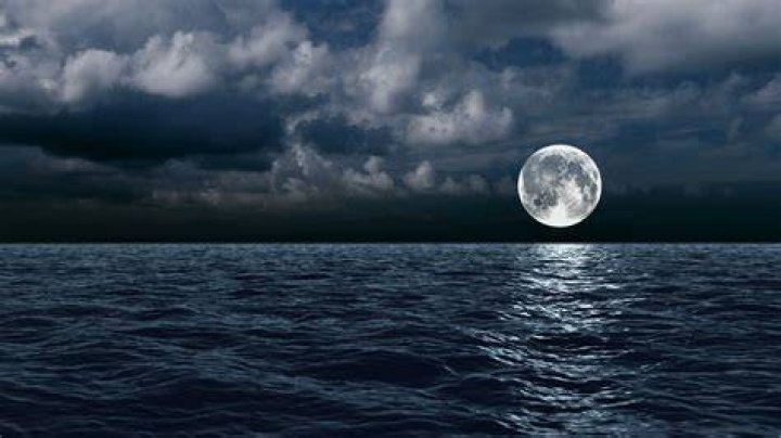 The moon over the sea in the clouds Motion Background Storyblocks